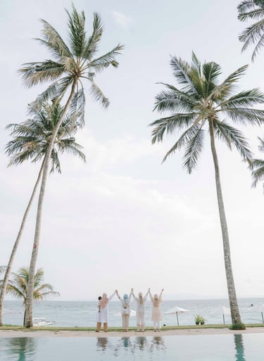 Friends standing near palm trees during photoshoot at Candi Beach Resort Karangasem Bali