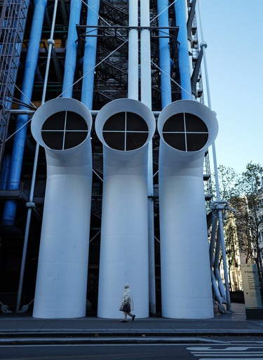 Pedestrian walking past three tall white vents on the façade of Centre Pompidou in Paris, By ACAT