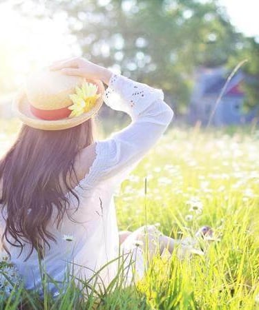 Person sitting in a sunlit field, symbolizing peace, reflection, and hope.