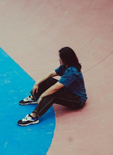 a person sitting on a skateboard on a ramp