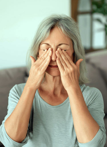Adult with myopia rubbing her eyes