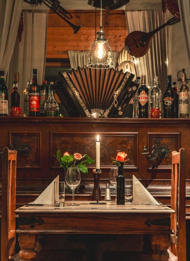 Romantisch gedeckter Tisch für zwei im rustikalen Restaurant mit Kerzenlicht und Musikinstrumenten.
