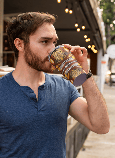a man drinking a cup of coffee in a city