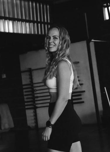 black and white picture. personal trainer posing for picture in gym setting