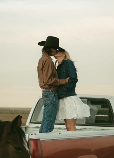 a man and woman kissing in the back of a truck