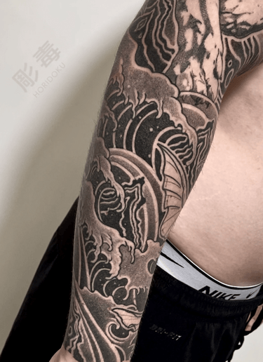 tatuaggio giapponese tradizionale fatto con onde sul braccio di un uomo eseguito da Horidoku 