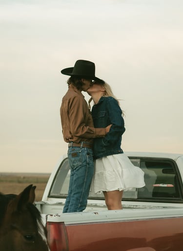 a man and woman kissing in the back of a truck