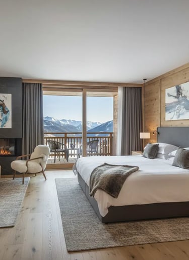 A modern luxury hotel suite in Ischgl featuring elegant wooden decor, a plush king bed, and a privat