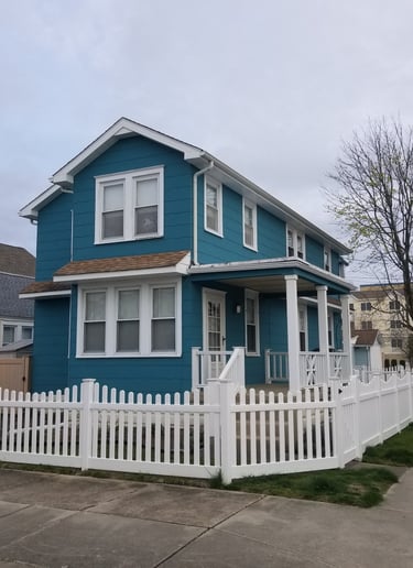 a blue house with a white picketd fenced in front of it