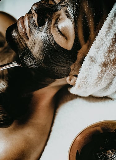 mulher deitada de olhos fechados fazendo argiloterapia.