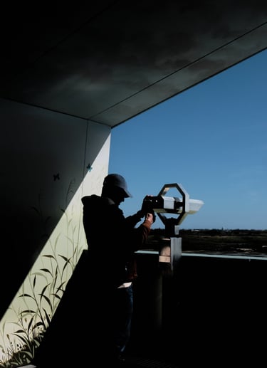 a man standing in front of binoculars