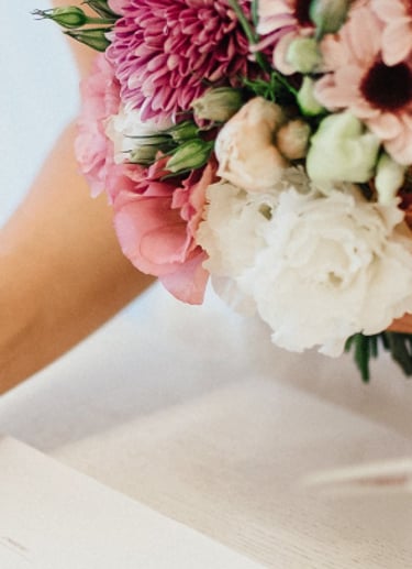 Bride signing the wedding register with bouquet—enquire to book your Glasgow wedding videographer.