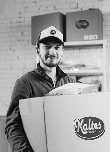 Colaborador segurando caixa de produtos da Kaltes chopeiras