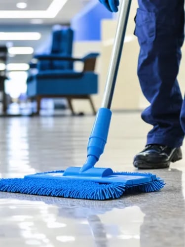 a person cleaning a floor with a broom