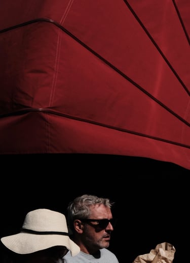 un homme et une femme descendant une rue, avec un store banne d'un café français