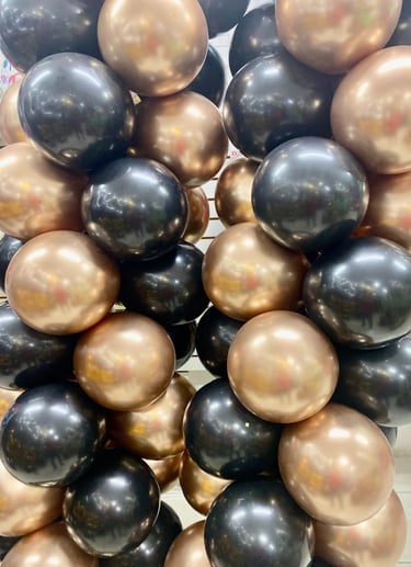 Columnas de globos cromados dorados y globos negros metalicos