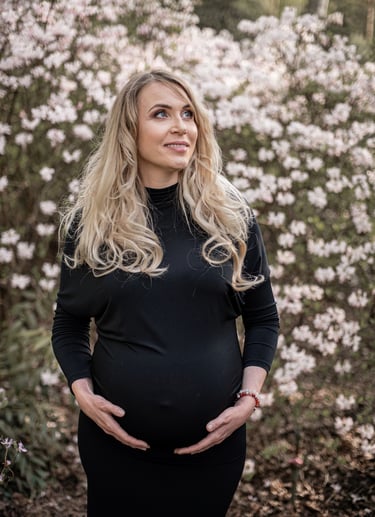 Nėštukės fotosesija prie gėlių su juoda aptempta suknele