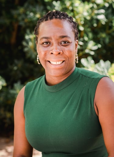 a woman in a green dress smiling at the camera