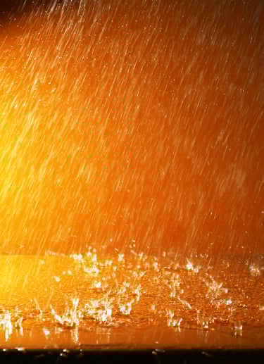 imagem de fundo alaranjado, sugerindo a noite, da chuva caindo sobre uma superfície pintada