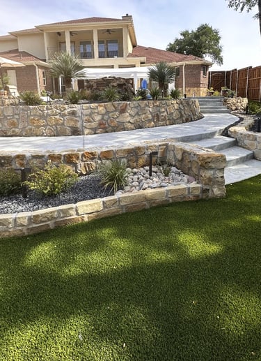 Hardscaping and stone work in a backyard patio with custom flowerbeds Estrada Fencing & Outdoors