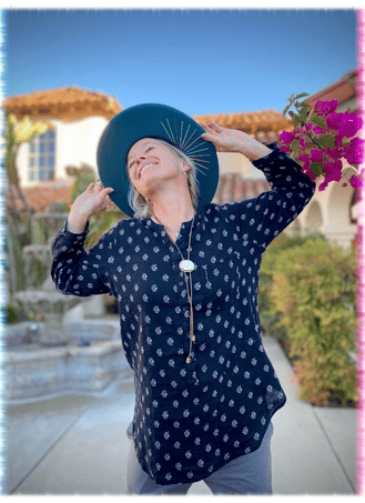 Kandace, co-owner of Green Bee Laser Cleaning & Restoration, smiling by a garden fountain