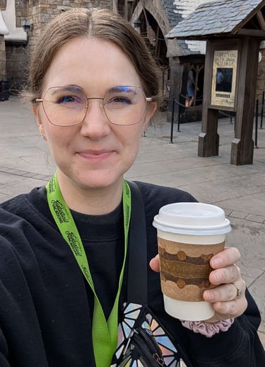 Katie Matzenbacher, Travel Advisor, holding a hot butterbeer in Hogsmeade at Universal Orlando