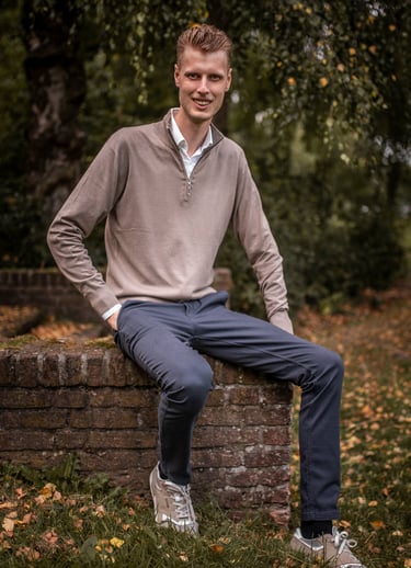 Wessel Dekker sitting on a brick wall with his feet on a brick wall