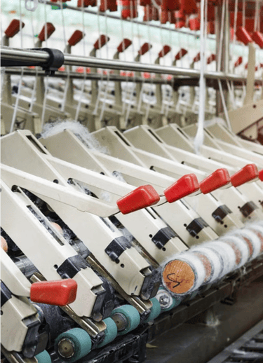 textile fabric manufacturer: A row of looms for textile fabrics