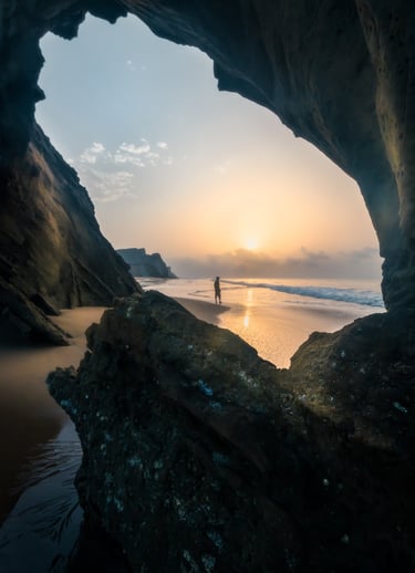 a person standing on a rock formation in the ocean . arbab naimat kasi , balochistan , sapat