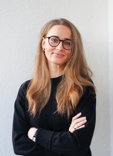 a woman with glasses and a black sweater