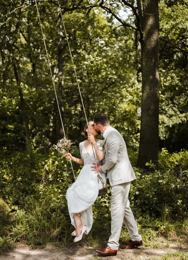 a bride and groom kissing on a swing swing