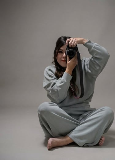 Fotográfa sentada sobre el piso con las piernas cruzadas