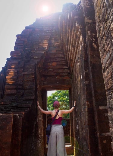 person standing inside ancient temple doorway with sunlight at my son sanctuary vietnam