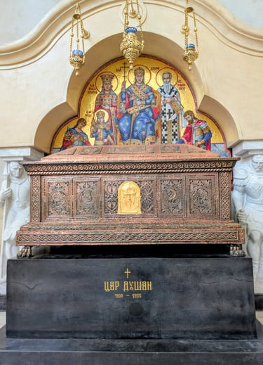 Ornate copper sarcophagus of Serbian Emperor Stefan Dušan inside St. Mark's Church with religious mosaics.