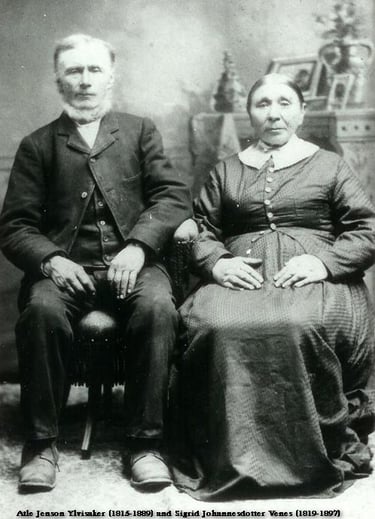 A man with a white beard sits next to a womanwith