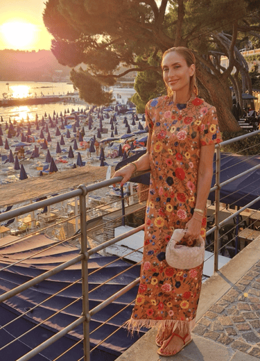 Woman in floral dress at sunset on beach in Santa Margherita Ligure, Italy.