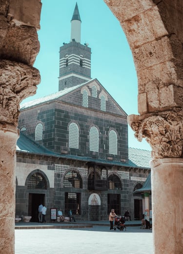 The Great Mosque of Diyarbakir framed by an ancient stone archway in Turkey.