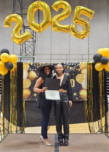 two women in black tops smiling and holding a certificate 