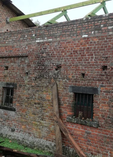 Ancien bâtiment en briques avec charpente en bois en cours de pose avant couverture de toiture.