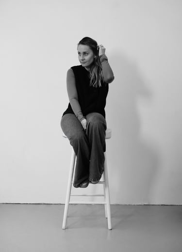 black and white woman sitting on the chair holding her hair