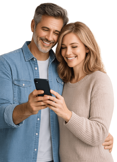 A happy couple smiling while looking at a smartphone screen against a black background.