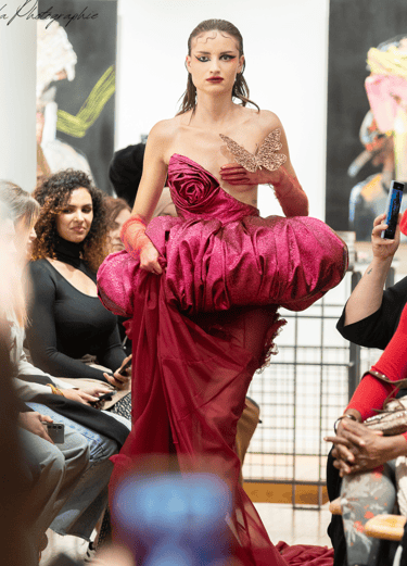 a woman in a red dress is walking down the runway
