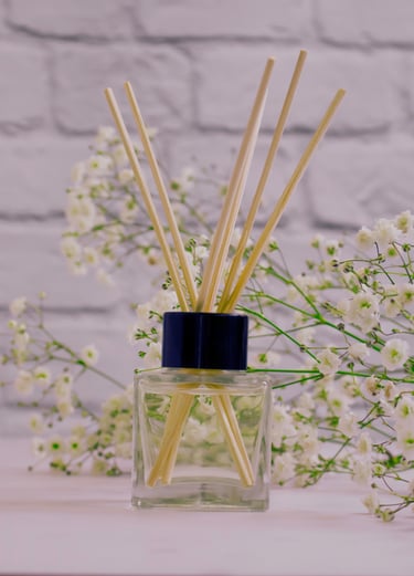 a glass bottle of perfume with a bunch of flowers