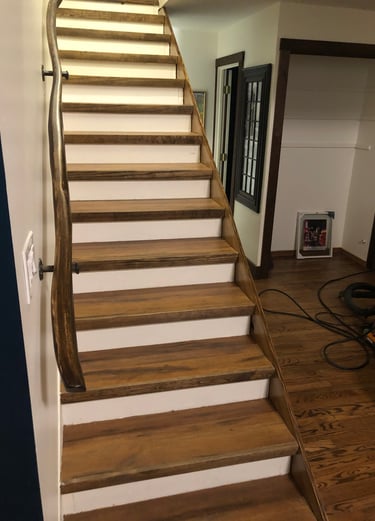 a custom staircase case with a custom carved hardwood railing