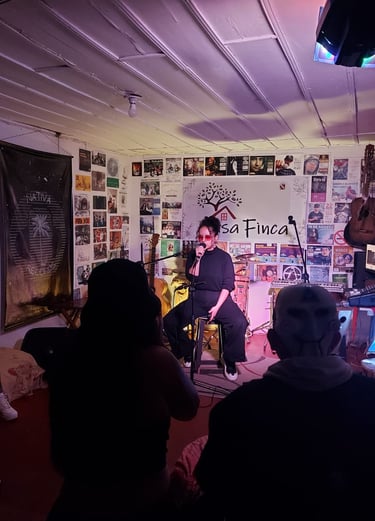 Una cantante se presenta en vivo sobre un pequeño escenario en un espacio musical íntimo