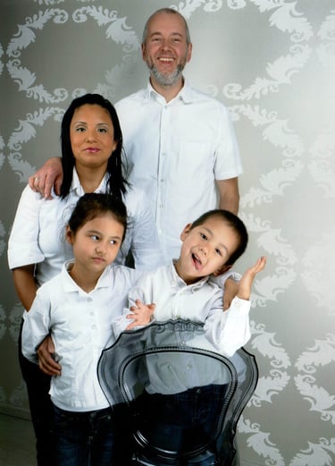 Jörg Grube mit Frau und zwei Kindern, alle mit weißem Hemd und schwarzer Hose