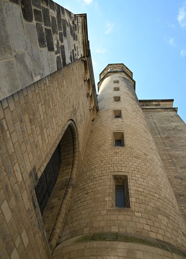 Low angle view of a tall stone tower and Gothic architecture of a medieval European cathedral.