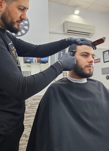 Peluquero dando su corte de pelo al cliente.