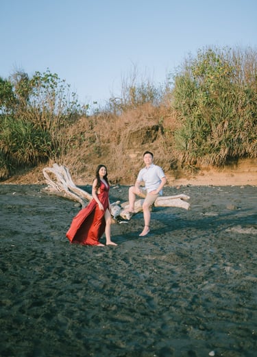 Wide beach portrait of intimate couple near rock formation at Pantai Nyanyi Bali.