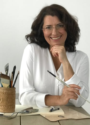 Mag Wilk a woman sitting at a table with a pencil and pencils
